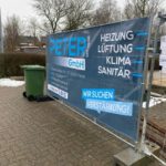 Ein Baustellenzaun mit einem Banner der Firma Peter GmbH