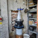 Ein Metallregal im Keller, davor ein Rohr